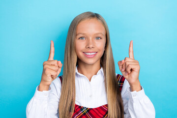 Poster - Closeup photo of little positive girl smile fingers up directing empty space ad new sale before september isolated on blue color background