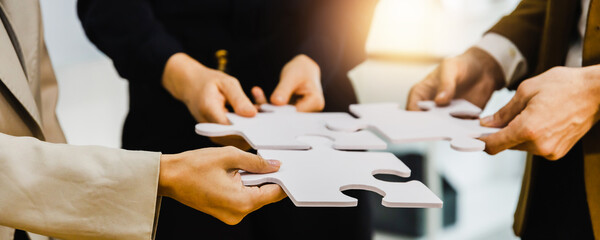 hand of successful business people connecting jigsaw puzzle. business solutions, success and strateg