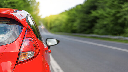 Wall Mural - Red car on the road at sunset.