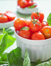 Fresh Organic Red Cherry Tomatoes Close Up With Water Drops In A White Bowl And Green Basil. Healthy Eating Concept.