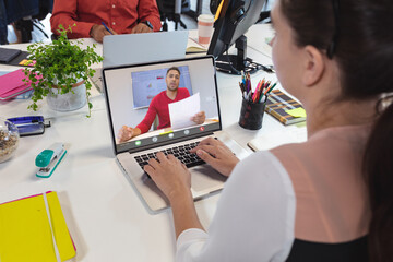 Sticker - Caucasian woman planning with male coworker on videocall over laptop at office