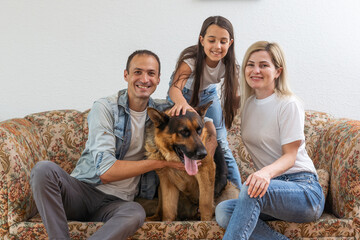 Wall Mural - Portrait of happy family with a dog having fun together at home