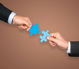 Canvas Print - Human hands hold a puzzle piece for teamwork concept