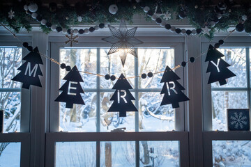 Merry sign in front of a window on a snowy day