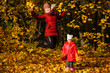 © Angelov - Mother and daughter having fun in the autumn park among the falling leaves.