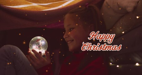 Wall Mural - Animation of happy christmas text over caucasian girl with snow globe