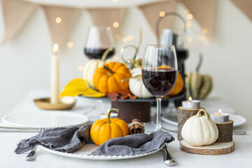 Idea for a beautiful autumn setting for thanksgiving family dinner or wedding. Orange pumpkin as decor. Cozy fall home atmosphere.