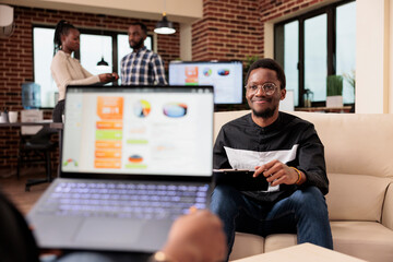 Colleagues doing teamwork partnership at job, analyzing business charts and graphs to create presentation and online report. People working with company data research diagrams on laptop.