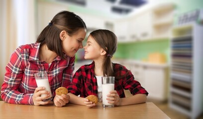 Canvas Print - Happy family enjoying breakfast, daughter drinking milk with mother