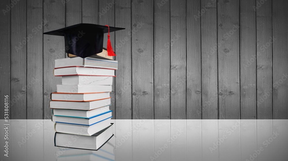 Graduation cap and stack of books on a table Stock Photo | Adobe Stock