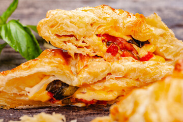 Wall Mural - Puff pastry with cherry tomatoes, mozzarella cheese and basil on wooden rustic table. Close up