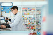 © 2B - A male pharmacist checks drug stocks in a community pharmacy.