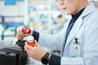 © 2B - A male pharmacist checks drug stocks in a community pharmacy.