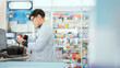 © 2B - A male pharmacist checks drug stocks in a community pharmacy.