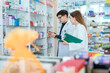 © 2B - Male and female pharmacists talk to check stocks of medicines in pharmacies. communication