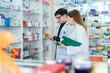 © 2B - Male and female pharmacists talk to check stocks of medicines in pharmacies. communication