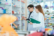 © 2B - Male and female pharmacists talk to check stocks of medicines in pharmacies. communication