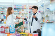 © 2B - Male and female pharmacists talk to check stocks of medicines in pharmacies. communication