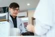 © 2B - Pharmacist Chayong standing and talking to the patient Buying medicines with a credit card online spending