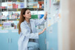 © 2B - A female pharmacist checks drug stocks in a community pharmacy.