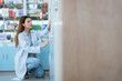 © 2B - A female pharmacist checks drug stocks in a community pharmacy.