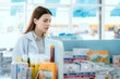 © 2B - A female pharmacist checks drug stocks in a community pharmacy.