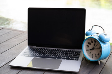 Wall Mural - Blue vintage alarm clock on notebook near a swimming pool in morning of summer. Summer travel concept. Vacation and holiday concept. Freelance concept.