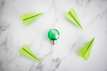 green light bulb idea next green paper planes metaphor of new ideas and inventions, green economy and innovation for the environment