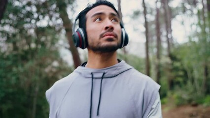 Wall Mural - Man walking in outdoor forest, music listening in cardio workout and focus in nature park. Healthy athlete training in woods, streaming fitness podcast with headphones and exercise on hiking path