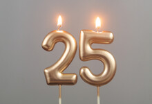 Burning Gold Birthday Candles On Gray Background, Number 25