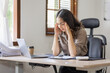 © David - Asian indian women are stressed while working on laptop, Tired asian businesswoman with headache at office, feeling sick at work copy space in workplace an home office.