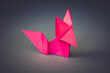 Pink paper fox origami isolated on a grey background