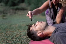 Crop Woman With Incense Stick Practicing Hypnosis With Calm Man Lying With Closed Eyes