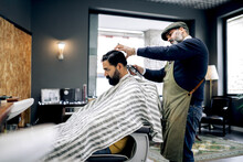 Client Getting Haircut In Modern Barbershop