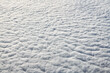 Breathtaking over clouds view from aircraft window, thick white blue clouds looks like soft foam, overcast with fresh frosty air. Beautiful cloudy sky view to troposphere, heavy cloudiness