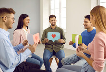 Group Of Happy Young People Sitting In Circle, Smiling And Showing Paper Chat Message Bubbles With Heart Symbols. Communication, Support, Positive Feedback, Friendship, Love, Online Dating Concepts
