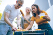 © chokniti - Happy family cheering with barbecue dinner outdoor - Group of people having fun at weekend meal - BBQ Food, taste and summer concept, Man cooking meat on barbecue grill at summer party