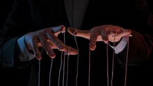 Man Hands With Strings On Fingers. Hands Close Up Pulling Strings. Man In Business Suit Manipulates Puppet. Puppeteer, Marionettist. Boss Controlling His Managers. Manipulation In Business, Government