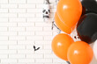 © Pixel-Shot - Halloween balloons near white brick wall, closeup
