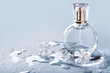 © colnihko - Glass perfume bottle, drops water and white flowers on blue background. Winter or spring floral fragrance