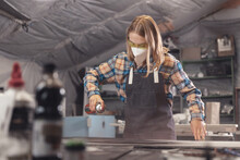 Industrial Worker Carpenter Woman Performs Painting Of Wooden Detail In Workshop
