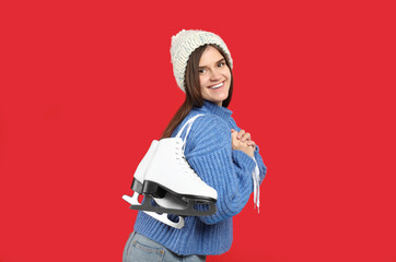 Canvas Print - Happy woman with ice skates on red background