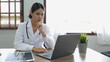 Portrait happy asian woman doctor, Telemedicine concept. Asian female doctor talking with patient using laptop online video webinar consultation while sitting in clinic office