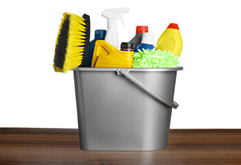 Grey bucket with car care products on wooden table against white background