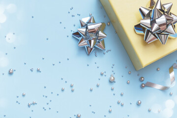 Wall Mural - flat lay christmas and new year gift box, pearls and bows top view on blue background
