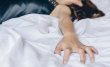 Cropped Shot View Of Woman Lying On The Bed And Do Something With Her Partner, Her Hand Pulling And Grab White Bed Sheet, Hand Woman Sign Orgasm.