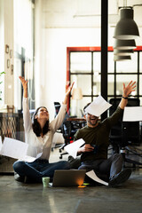 Wall Mural - Colleagues in office. Businesswoman and businessman sitting on the floor. Colleagues working on the project..