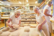 © Robert Kneschke - Baker team with boss and apprentices baking bread