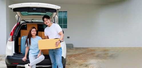 Wall Mural - Happy aisan couple help moving cardbord boxes to new house together. Moving day.