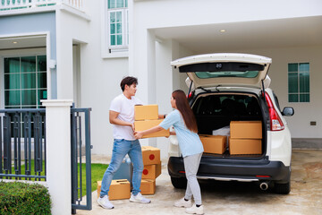 Happy aisan couple help moving cardbord boxes to new house together. Moving day.